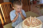 Karolek podczas zdmuchiwania świeczek urodzinowych 